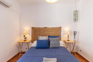 阿洛拉Casa Randonneur, traditional townhouse in Álora.的一间卧室配有蓝色的床和两张边桌