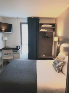 南特The Originals City, Hôtel Novella, Nantes Centre Gare的配有一张床和一张书桌的酒店客房