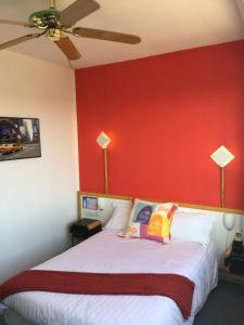 维耶尔宗艾尔驰酒店的一间卧室设有一张红色墙壁的大床