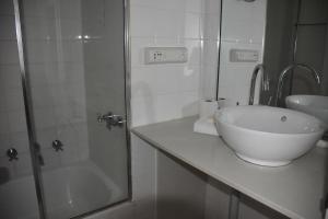 悉尼Accommodation Sydney Studio with balcony apartment的白色的浴室设有水槽和淋浴。