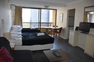 悉尼Accommodation Sydney Studio with balcony apartment的酒店客房设有一张床和一个带桌子的厨房