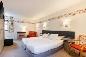 凯恩海豚和修道院Spa餐馆酒店的酒店客房,配有白色的床和椅子