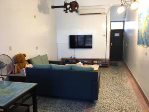 布袋瑞恒行館Reui Heng Guesthouse的客厅配有蓝色的沙发和泰迪熊