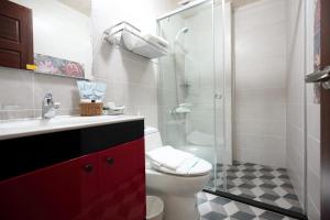 花莲市民乐缘民宿 的一间带卫生间和玻璃淋浴间的浴室