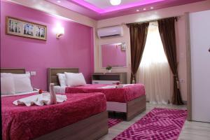 开罗阿民酒店的紫色卧室配有两张床和镜子