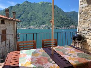 波尼亚纳拉廖La Casa del Mastro - Como Lake的阳台顶部带雨伞的桌子