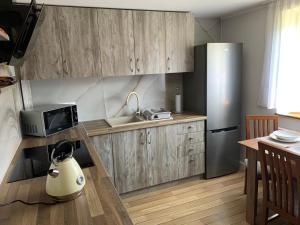 奥斯特罗沃Apartament Zalesie的厨房配有木制橱柜和不锈钢冰箱。