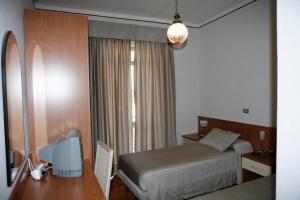 瓦雷塞利古雷阿尔伯格阿米奇酒店的酒店客房配有一张床、一张书桌和一台电视。