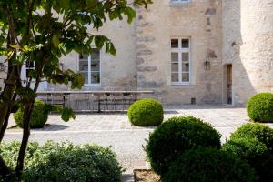AnthenayFerme du Château的前面有长凳和灌木的建筑