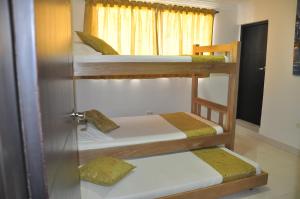 卡塔赫纳Casa Hotel Manga Mar的带窗户的客房内的三张双层床