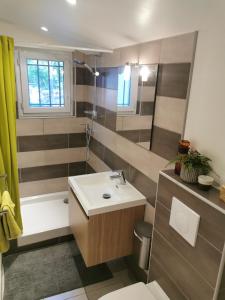 勒吕克Studio de charme en Provence的浴室配有水槽、淋浴和浴缸。
