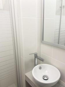 塞普特梅斯·莱瓦隆勒芒酒店的浴室设有白色水槽和镜子