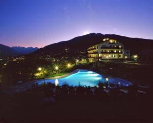 奥斯塔米勒鲁西酒店的享有酒店夜间泳池的景色