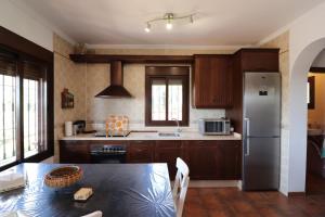 托罗克斯Villa Magnolias SpainSunRentals 1093的厨房配有桌子和不锈钢冰箱。