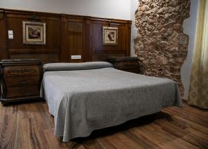 莫蒂利亚德尔帕兰卡尔塞托斯酒店餐厅的一间卧室设有一张床和石墙
