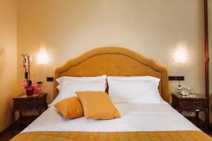 基安奇安诺泰尔梅怡东大酒店的卧室配有一张带白色床单和枕头的大床。