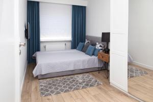 赫尔Apartament Silva View的一间卧室配有一张带蓝色窗帘的床和一扇窗户