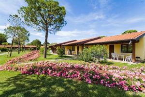 佩斯基耶拉德加达加达假日公园的一座花园,在房子前方种有粉红色的花朵