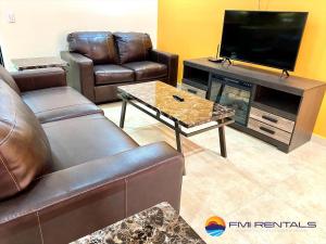 佩尼亚斯科港Linda Vista 513的客厅配有皮革家具和平面电视