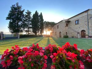 波马兰切Agriturismo L'Antica Quercia的院子前有红花的房子