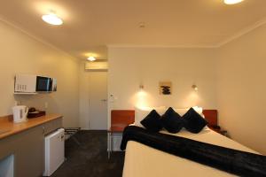 旺格努伊BK蒙高利亚汽车旅馆的配有黑色枕头的床的酒店客房