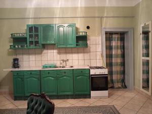 奥巴曹洛克Rokoko Apartman的厨房配有绿色橱柜和炉灶。