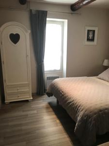 塞雷斯特Au cœur de Céreste的一间卧室设有一张床和一个窗口