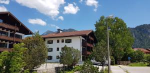因泽尔Alpina Inzell Wohnung 454的一座白色的建筑,有树木和山脉