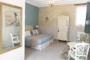 Saint-Vigor-le-GrandLes Pérelles的一间卧室配有一张床、镜子和椅子