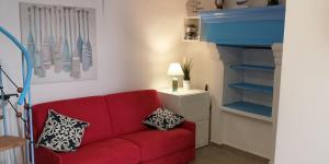 维耶斯泰PASSIONE VACANZE的客厅里一张带两个枕头的红色沙发