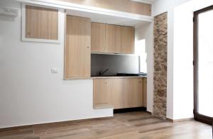 切法卢Cortile Osterio XIV的厨房配有木制橱柜和冰箱。