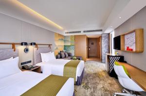 广州广州南湖假日酒店的酒店客房设有两张床和电视。