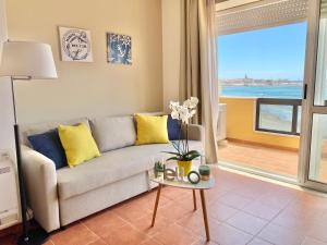 阿尔盖罗Appartamenti Sole 1的带沙发的客厅,享有海景