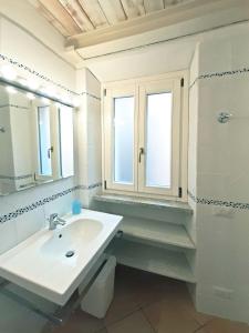 坎波内莱尔巴Appartamento elegante a Marina di Campo的白色的浴室设有水槽和镜子