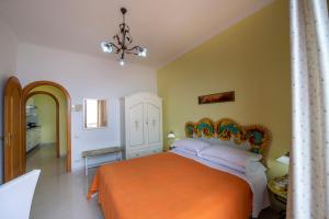 普莱伊亚诺利曼尼花园公寓式酒店的一间卧室配有一张带橙色床罩的床
