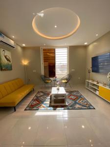 艾卜哈A - 369 مقابل الراشد مول的客厅配有黄色的沙发和桌子