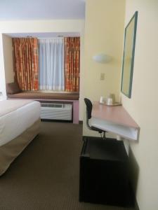 诺克斯维尔Cedar Bluff Inn的酒店客房设有一张桌子、一张床和一个窗户。