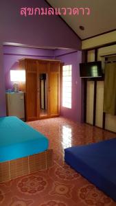 尖竹汶สุขกมลรับอรุณแฝด2ห้อง的紫色墙壁和厨房内的两张床