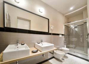 菲乌吉旅游健康及美容酒店的一间带水槽、卫生间和镜子的浴室