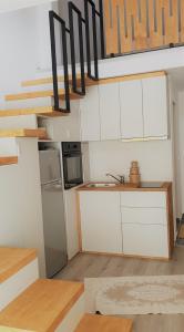 大特尔诺沃Cattleya's Loft的一间小厨房,配有白色的橱柜和楼梯