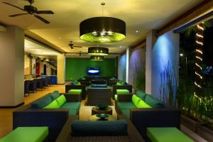 登巴萨普拉亚酒店的大堂设有绿色沙发和酒吧