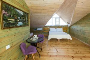 胡日尔Villa Malina Olkhon Baikal的小木屋内的卧室配有一张床和紫色椅子