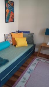 AlquerubimQuinta D'Avó Amélia的客房内的蓝色沙发,配有色彩缤纷的枕头