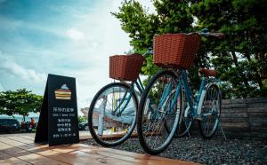 鹅銮鼻垦丁船帆石 莎莎之拉梦海景民宿的两辆自行车停在标牌旁边,上面有篮子