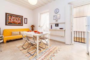 加的斯Alojamientos Cadiz Sol的客厅配有桌子和黄色沙发