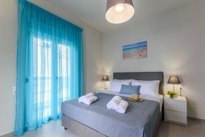 斯塔里斯Seashell Apt 2的一间卧室配有一张蓝色窗帘的大床