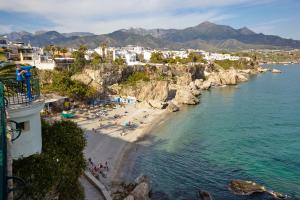 内尔哈Charming Nerja Hostel的和水中的人一起欣赏海滩的空中景色