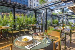 马德里梅利亚马德里塞拉诺酒店的户外庭院设有桌椅和窗户。