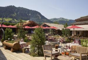 梅杰夫玛丽菲尔姆酒店的餐厅配有桌椅,位于山脉的背景中