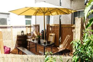 汉堡汉堡里珀巴恩城市公寓的露台上的一张带黄伞的桌子